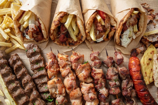 Greek street food gyro sliced meat pita bread wrap chiken and pork souvlaki skewer overhead