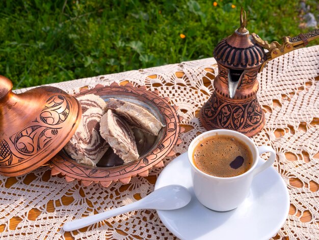 Greek Turkish brewed coffee and marble halva on a table with a handmade tablecloth in Greece