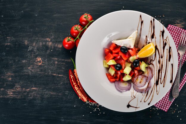 Greek vegetable salad with brie cheese On a wooden background Top view Copy space