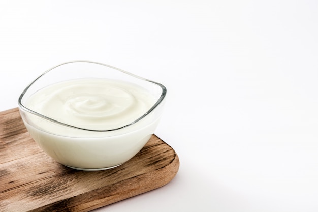 Greek yogurt in glass bowl isolated on white surface