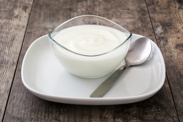 Greek yogurt in glass bowl on wooden table