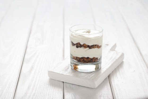 Yogurt greco con muesli in vasetto di vetro parfait