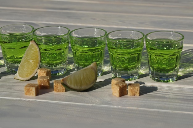 写真 コピー スペースを持つ白い木製の背景に緑のアブサン飲み物パターン