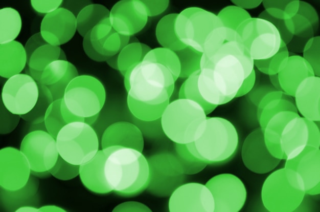 Green abstract Christmas blurred luminous background. Defocused artistic bokeh lights image