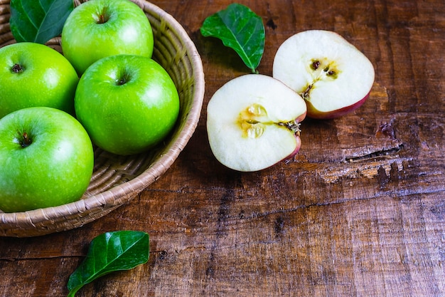 Green apple in a basket on a wooden table