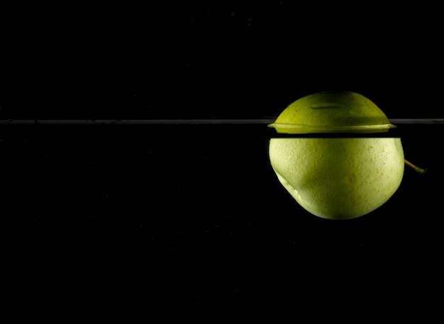 Photo green apple floating on water