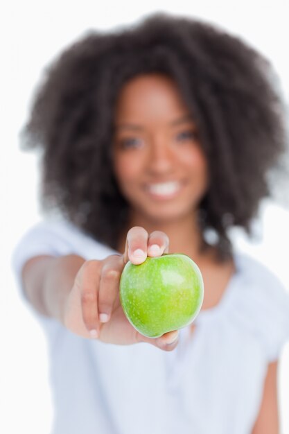 Photo green apple held by a young woman with curly hair