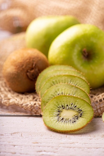 Green apple and kiwi green apples and kiwi fruit laid on rustic wood with rustic fabric selective focus