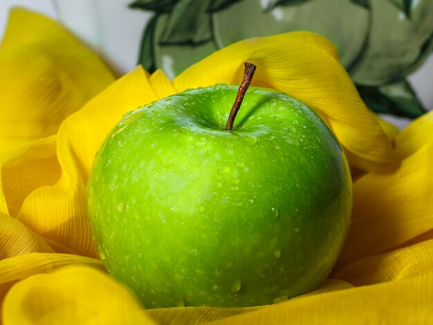 Green apple placed on the yellow cloth