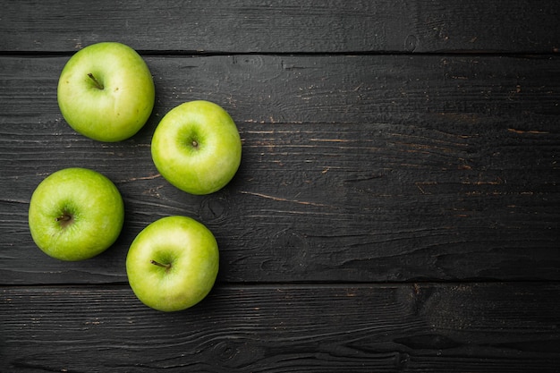 Green apple set, on black wooden table background, top view flat lay, with copy space for text