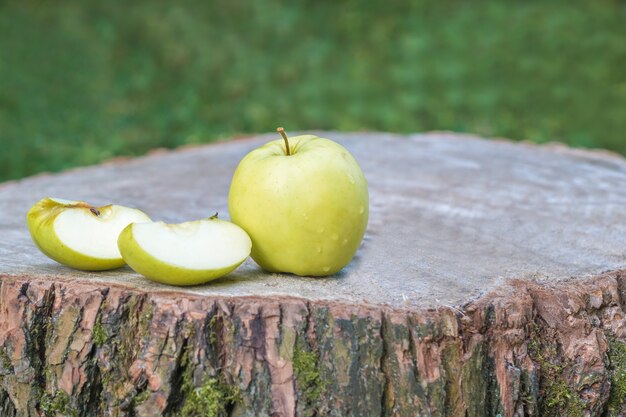 A green apple on a wooden stump