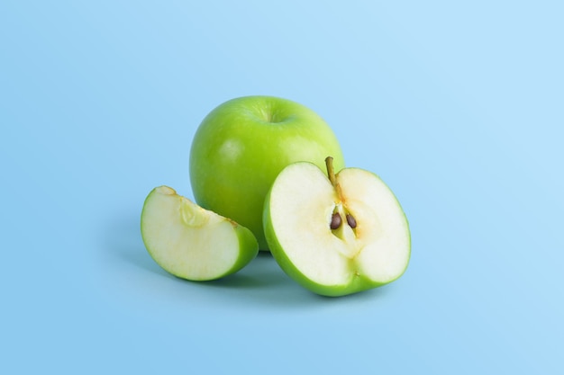 Green apples are arranged in such a way that they are both half-full and half-split and are a popular fruit