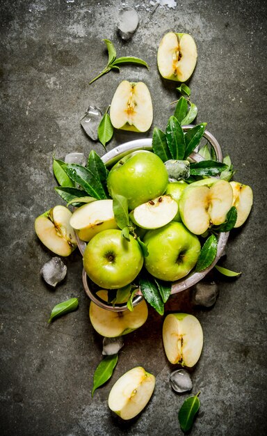 Green apples in a Cup with ice . On rustic stone table. Top view