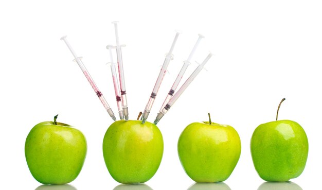 Green apples and syringes isolated on white