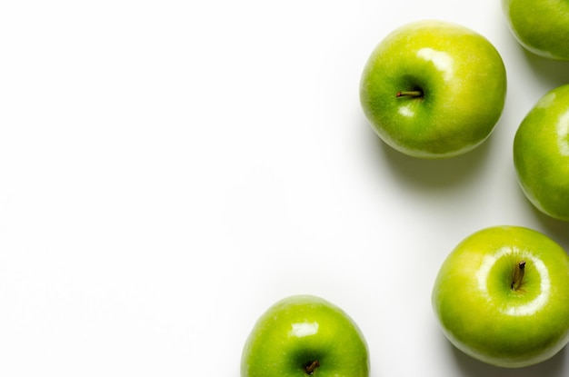 Green apples on white background with copy space.