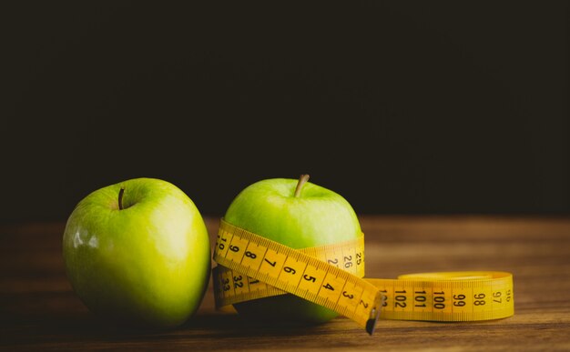 Green apples with measuring tape