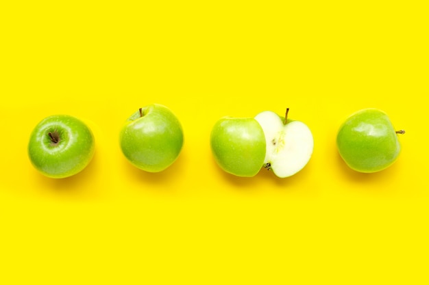 Green apples on yellow. Top view