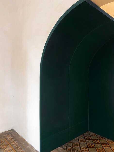 Photo a green arch in a room with a white wall behind it.