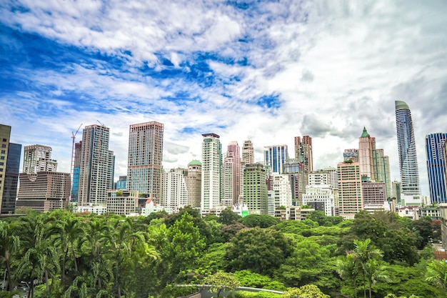Зеленая зона перед центром мегаполиса Бангкока с высокими зданиями вокруг под открытым небом.