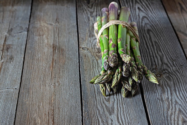 Asparagi verdi su sfondo di legno scuro luogo di concetto di cibo crudo per spazio di copia