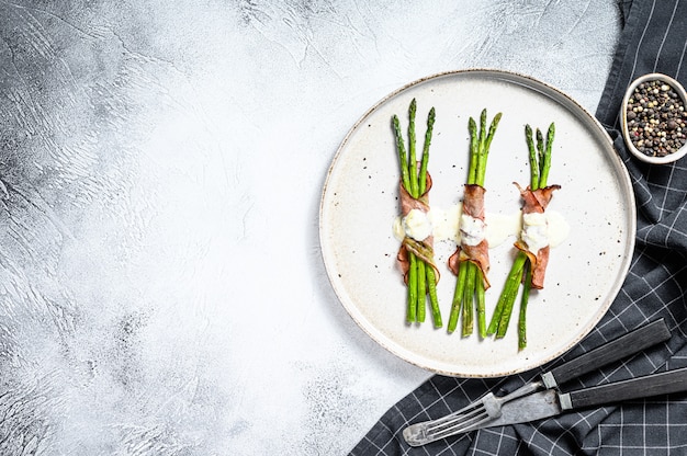 Green asparagus with parma ham.  White background. Top view. Copy space