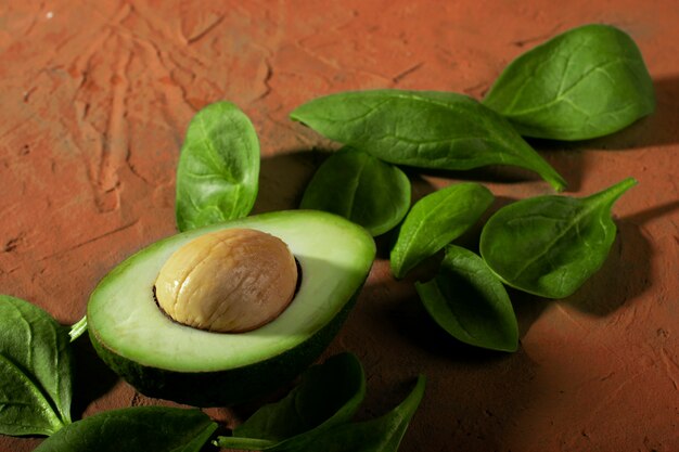 Зеленый авокадо на текстурном фоне. Целые и половинки