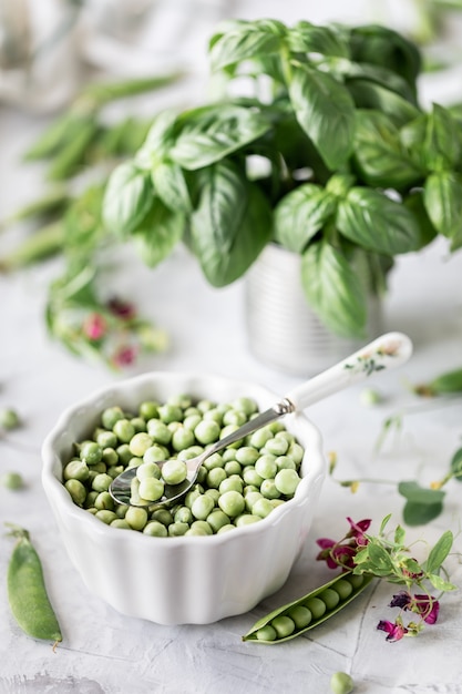 Green baby peas in pan on white background.