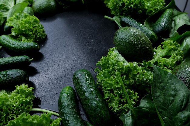 Green background of fresh lettuce leaves avocado cucumber zucchini.