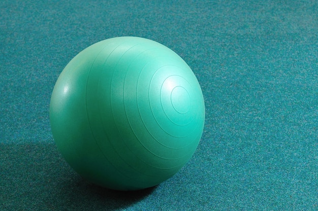 Green ball for fitness on azure background