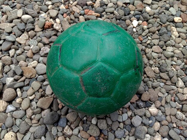 Foto una pallina verde a forma di piccolo cerchio su un ciottolo