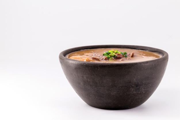 브라질에서 콩 국물이라고 하는 야채와 고기를 넣은 녹색 콩 수프는 흰색 배경에 고립되어 있습니다.