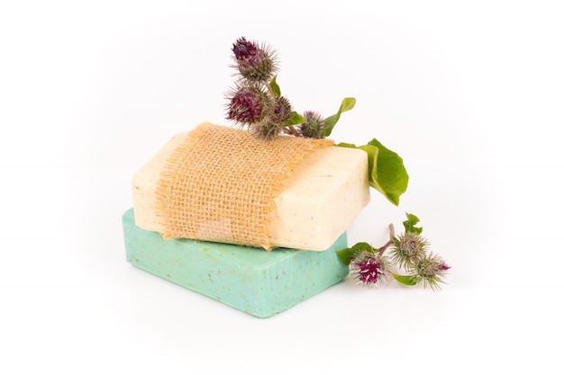 Green and beige homemade herbal soap bars with burdock flowers