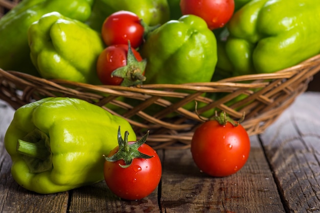 Green bell pepper and tomatoes in wicker basket