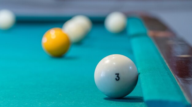 Green billiard table with white balls. Closeup