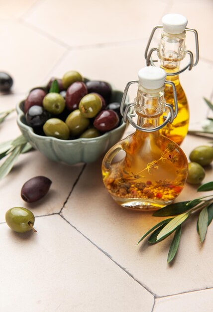 Green and black olives with olive oil on tiled kitchen counter