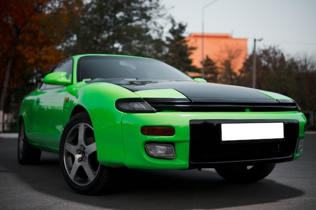 Green and black sport coupe car with big wheels. Japanese oldtimer.