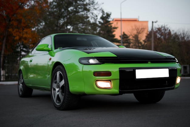 Green and black sport coupe car with big wheels. Japanese oldtimer.