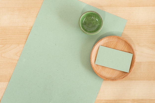 Green blank business cards on wooden office table Recycled paper Business card Mock Up