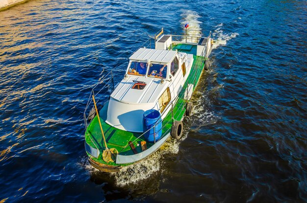 A green boat is in the water with the word sea on it