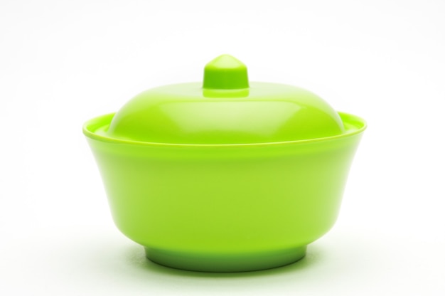 Green bowl for fruits and vegetables on an isolated white