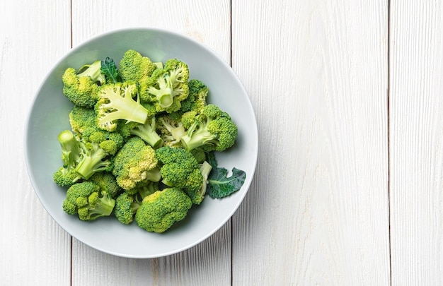 Green broccoli in a plate on a white wooden background Healthy dietary food