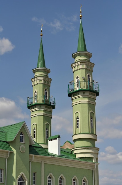 A green building with a green roof and a green roof with a flag on it.