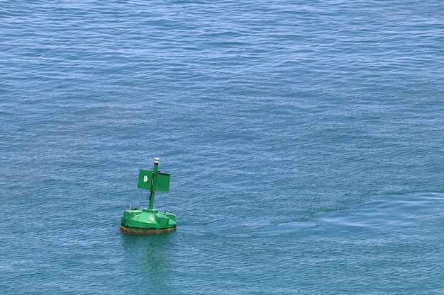 Foto una boa verde galleggia in mare aperto con punte per impedire agli animali di atterrarvi sopra
