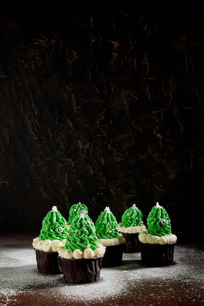 写真 クリスマスツリーの形で白いクリームを追加したグリーンケーキには、粉砂糖を振りかけたさまざまな順序があります