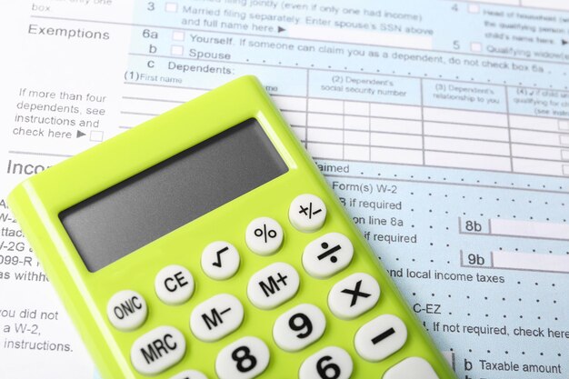 Green calculator on document closeup view Tax accounting