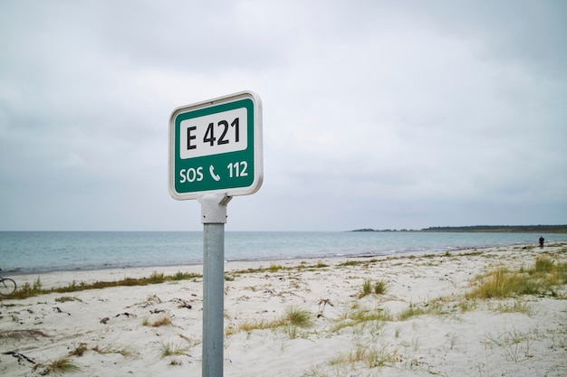 A green call for help sign at the beach