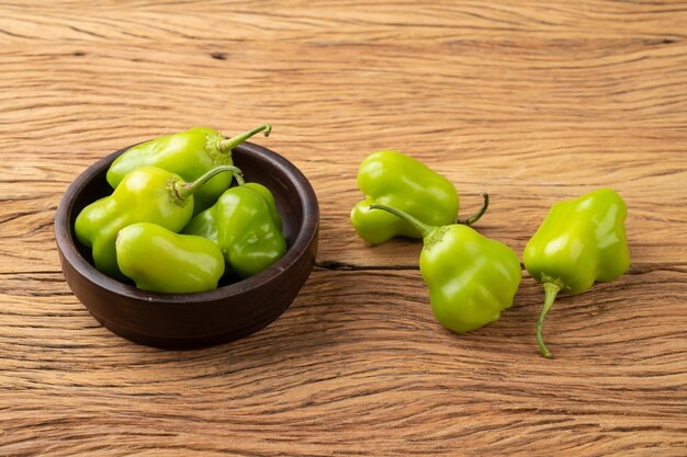 Green cambuci pepper, brazilian cuisine ingredient, on a bowl over wooden table.