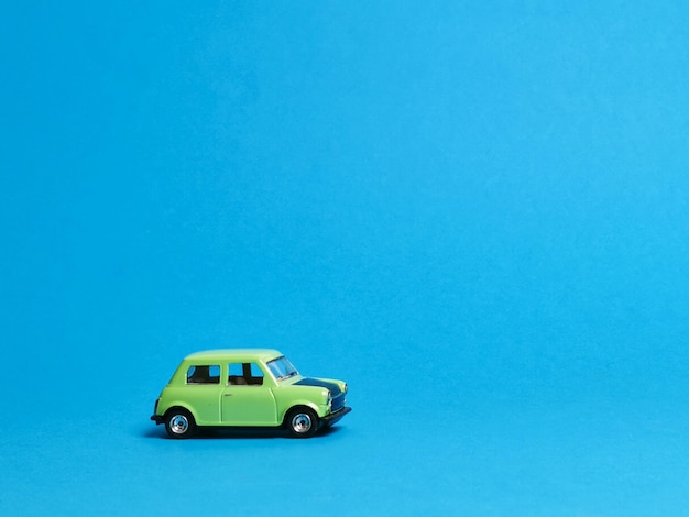 A green car is on a blue background with a blue background