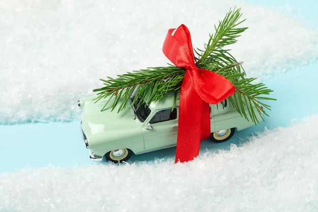 A green car with a Christmas tree and a red bow