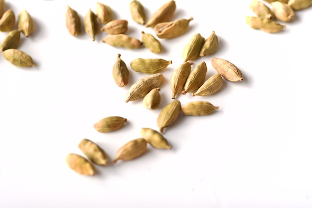 Green cardamom pods on white background